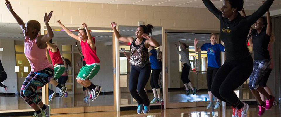 Group exercise class participants mid-jump during a dance class