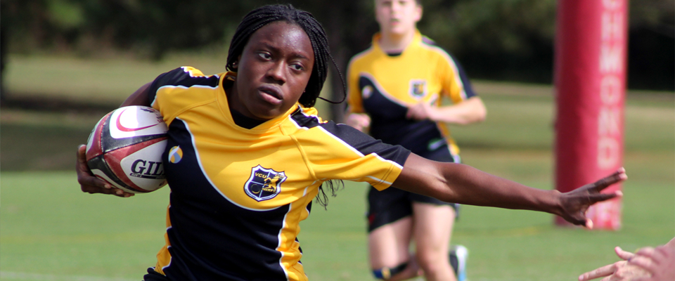 A VCU women's rugby club player runs while holding the ball