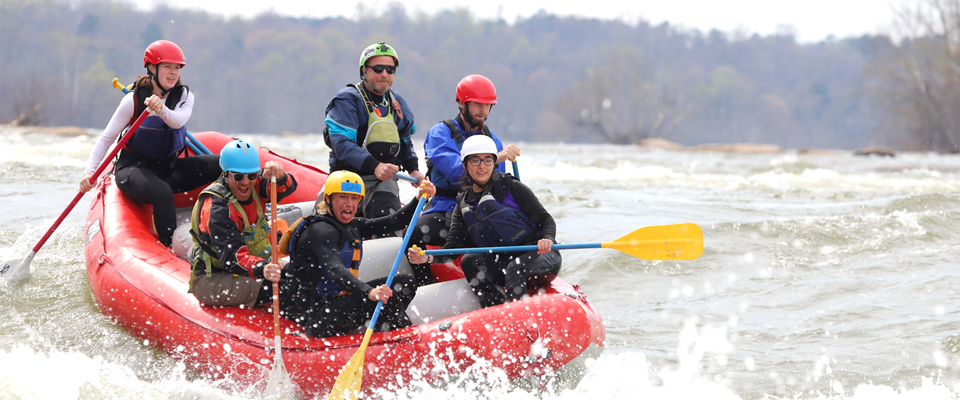 A group of whitewater rafters paddling on the James River