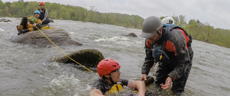 Students in cold water gear practicing rescue techniques in the James River
