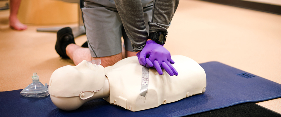 close up of person practicing CPR on a mannequin